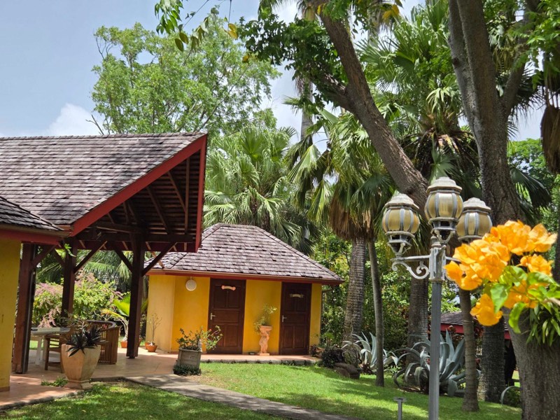Habitation créole jaune, lampadaire ancien et bougainvillier orange au Jardin de Beauvallon, Basse-Terre